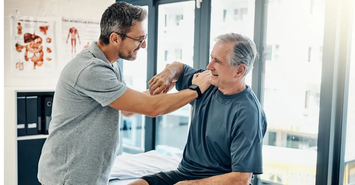 Physiotherapist assessing an older patient's shoulder mobility